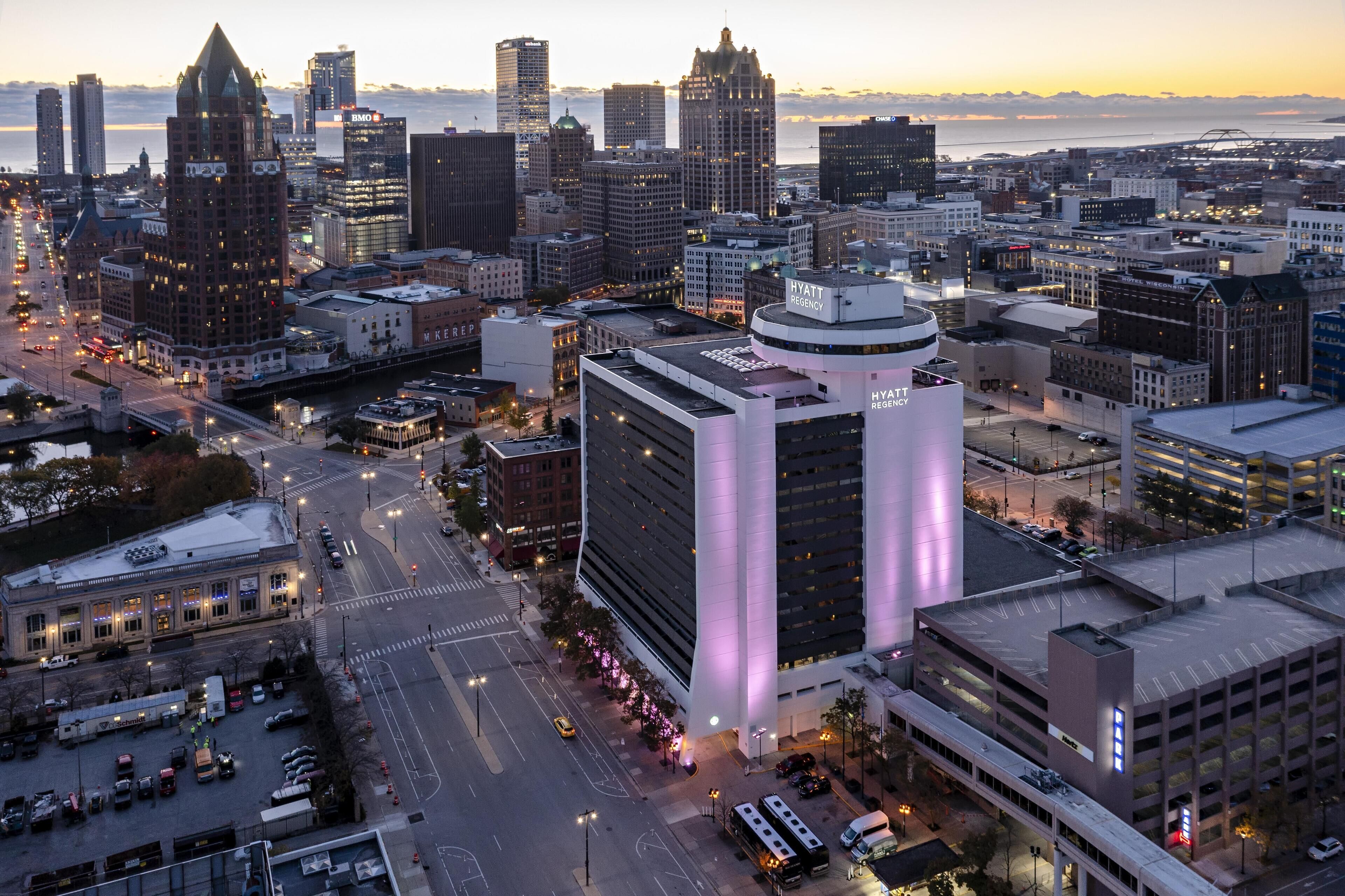 Un paisaje urbano con un edificio destacado que muestra un letrero iluminado grande para Hyatt Regency.