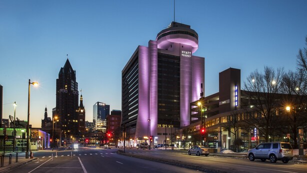 A modern hotel with a prominent curved entrance and a visible sign for the Hyatt Regency.