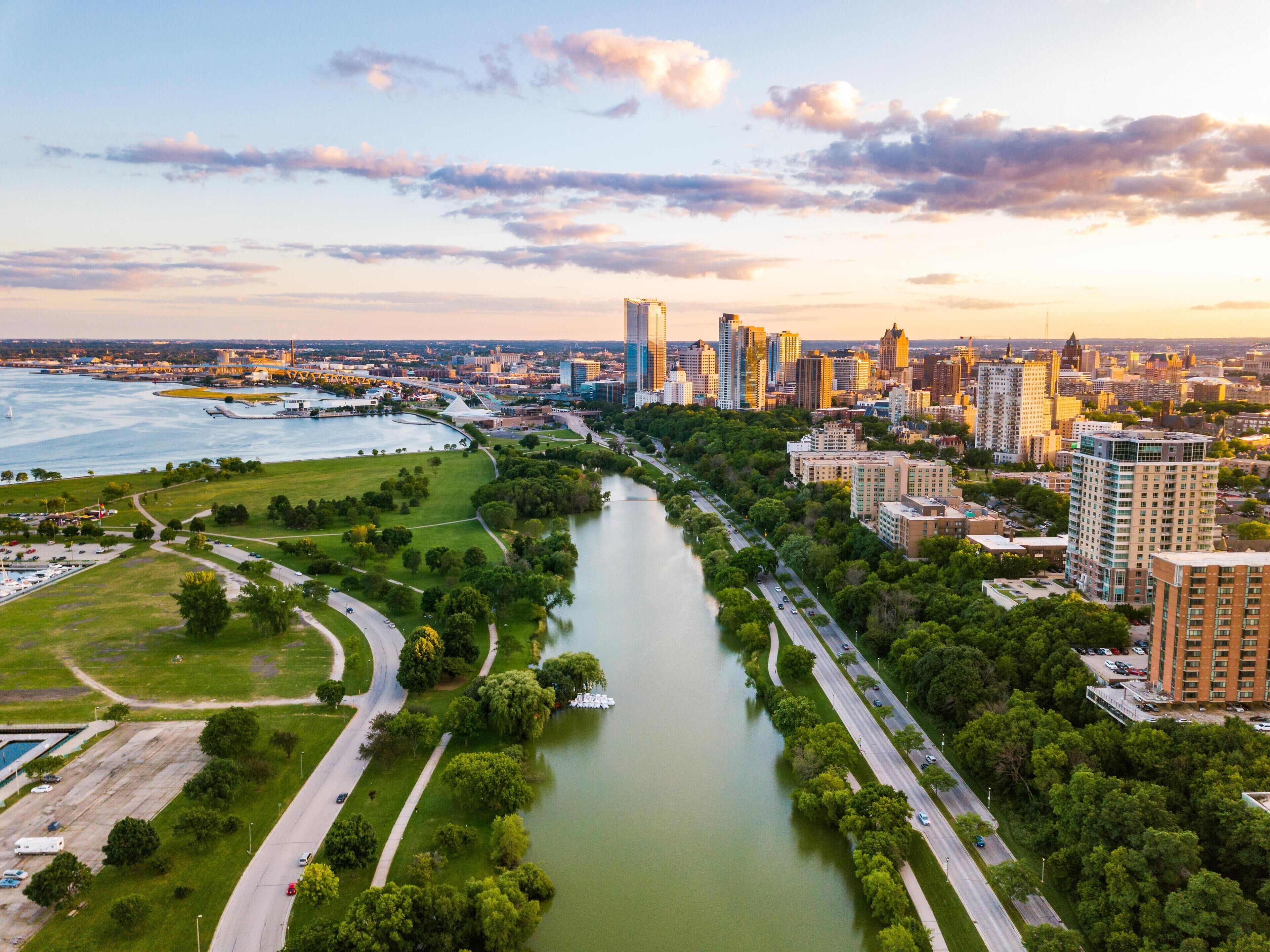 A river running through a city with modern buildings and a park area.