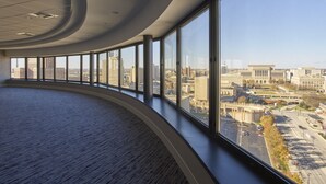 A spacious, curved interior with large windows offering views of a cityscape.