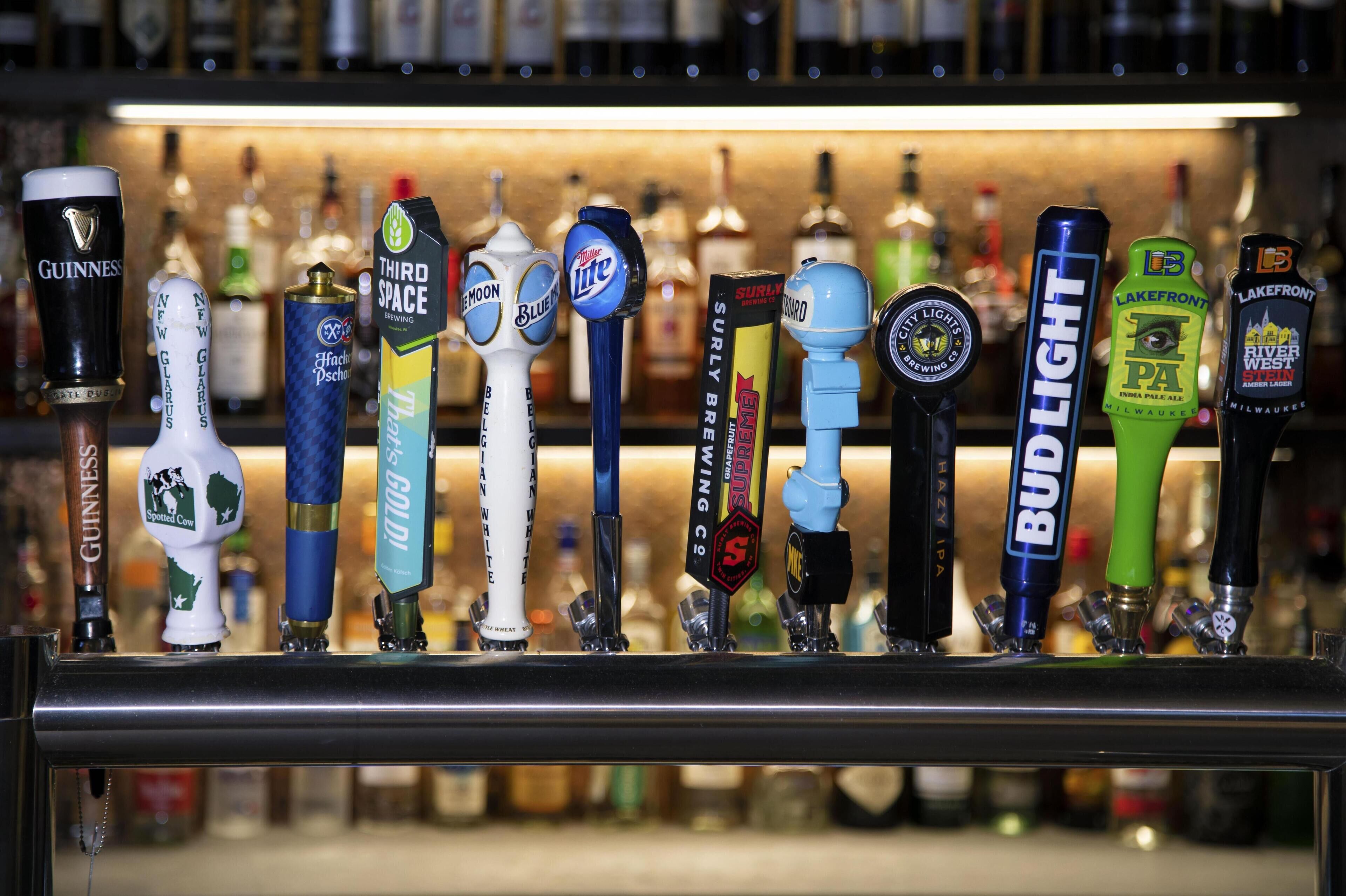 Un bar con diferentes grifos de cerveza, incluyendo marcas como Guinness, Bud Light y Third Space Brewing.