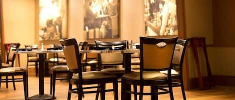Un restaurante con suelo y mesas de madera, con sillas.