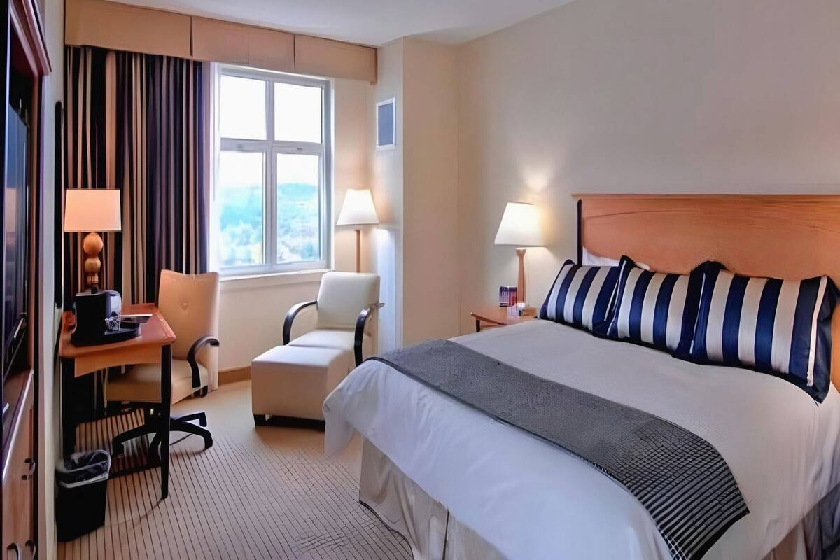 Luxe beddengoed, een kluis op de kamer, een bureau, een laptopwerkplek