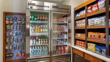 A vending machine stocked with various snacks and beverages, including chips, popcorn, and bottled drinks.