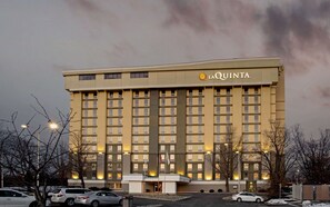 Un hôtel à plusieurs étages, reconnaissable à son grand panneau « La Quinta », doté d’une façade symétrique avec des fenêtres régulièrement espacées et une entrée centrale.