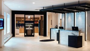 A modern hotel lobby with a reception desk, a private dining area, and a well-lit interior. - Delta Hotels by Marriott Utica (Utica)