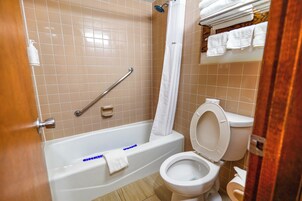 Un baño con bañera, inodoro y cortina de ducha.