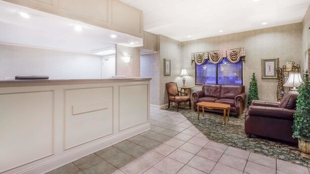 A reception area with a counter, seating, and a decorative window.