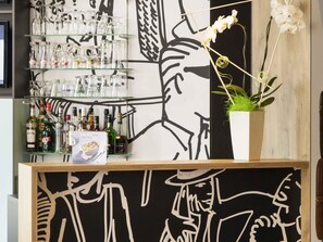 A bar area with shelves of glasses, bottles, and a potted orchid. - ibis Poitiers Centre (Poitiers)