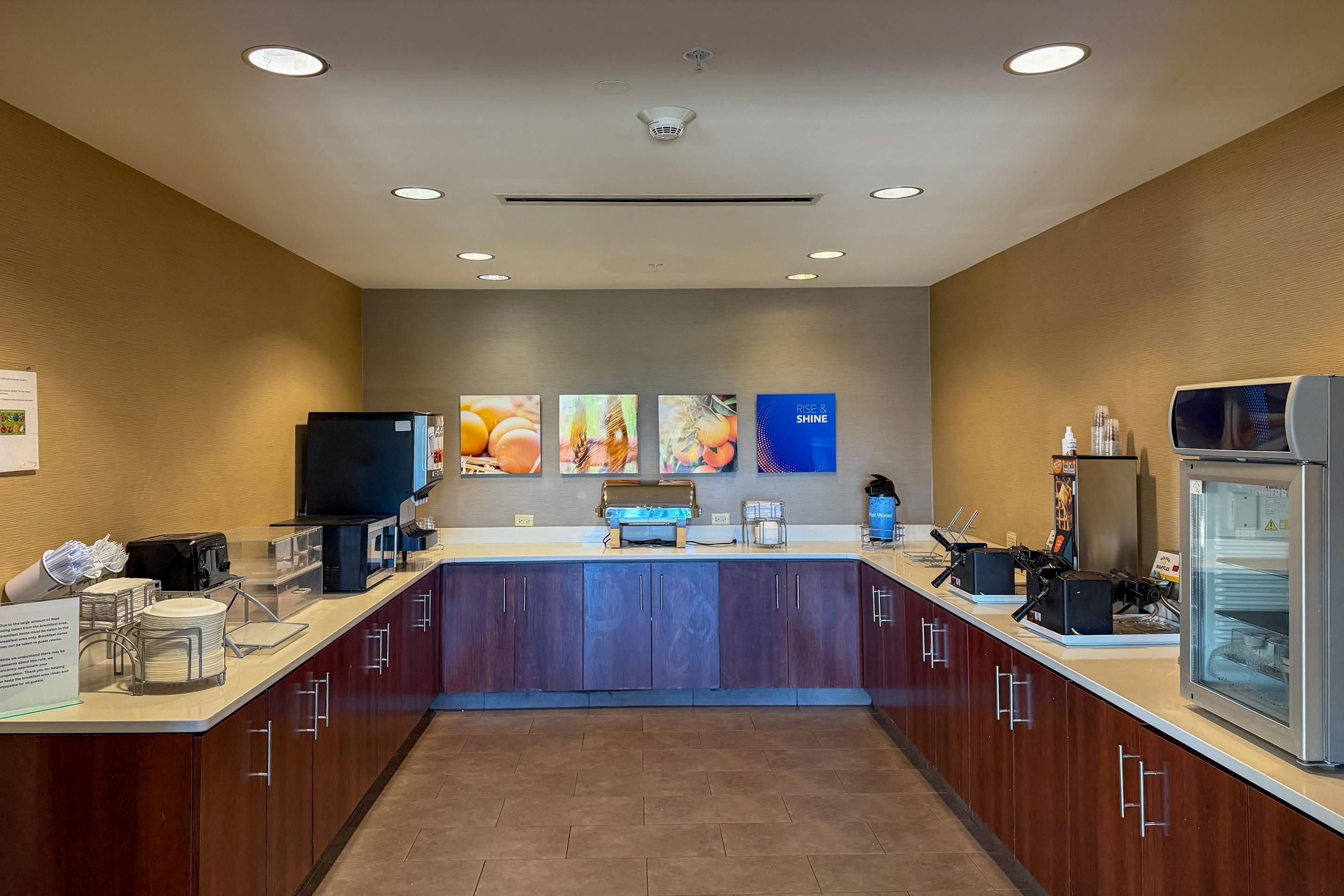 A modern kitchen with a central island, equipped with a coffee machine, microwave, and refrigerator.