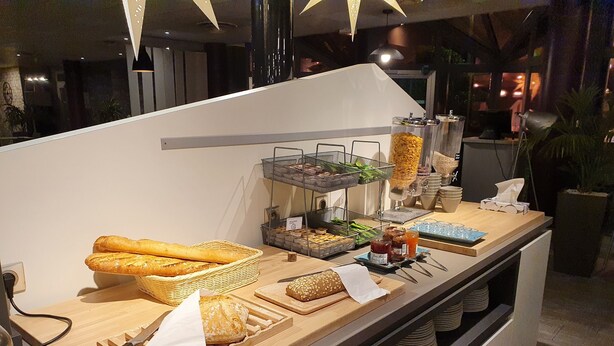 A buffet setup with various food items and condiments. - ibis Styles Paris Roissy CDG (Roissy-en-France)