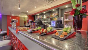 A bar area with a counter displaying food items and a selection of drinks. - ibis Styles Paris Roissy CDG (Roissy-en-France)