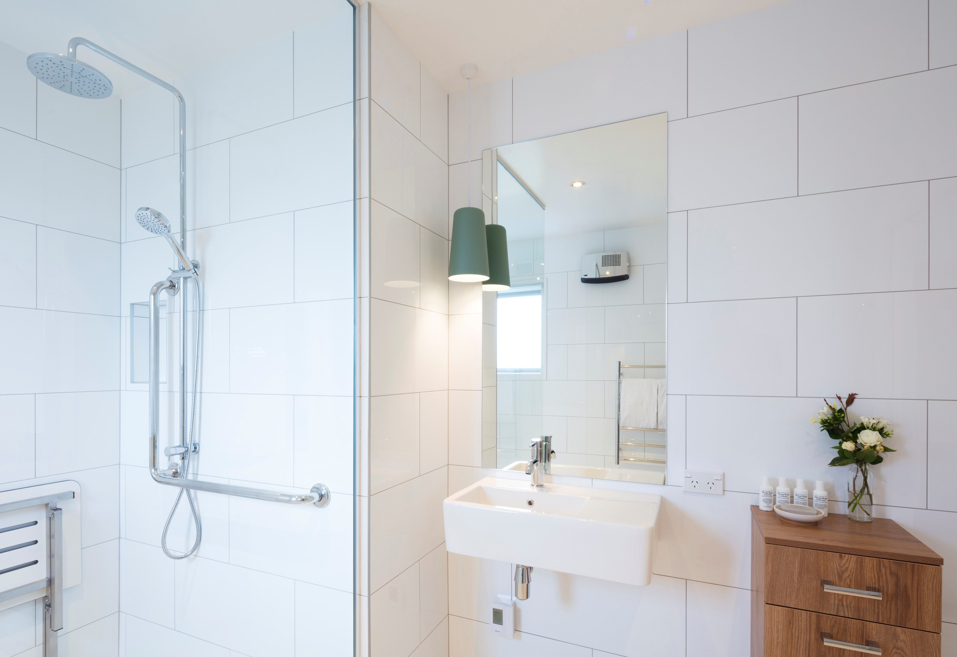 Ein modernes Badezimmer mit Dusche, Waschbecken und Waschtisch.