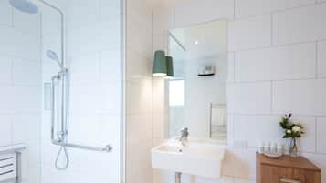 Ein modernes Badezimmer mit Dusche, Waschbecken und Waschtisch.