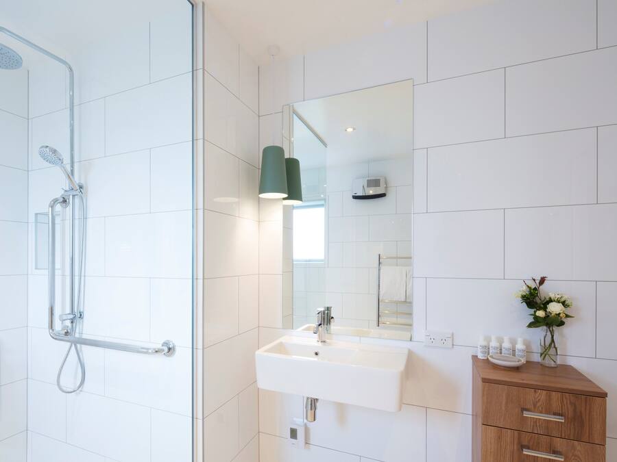 Ein modernes Badezimmer mit Dusche, Waschbecken und Waschtisch.
