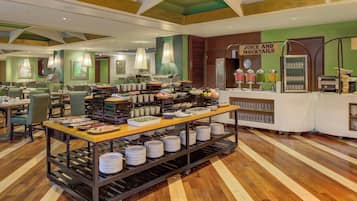 A buffet area with a variety of food items, a juice and mocktails station, and a seating area with tables and chairs.