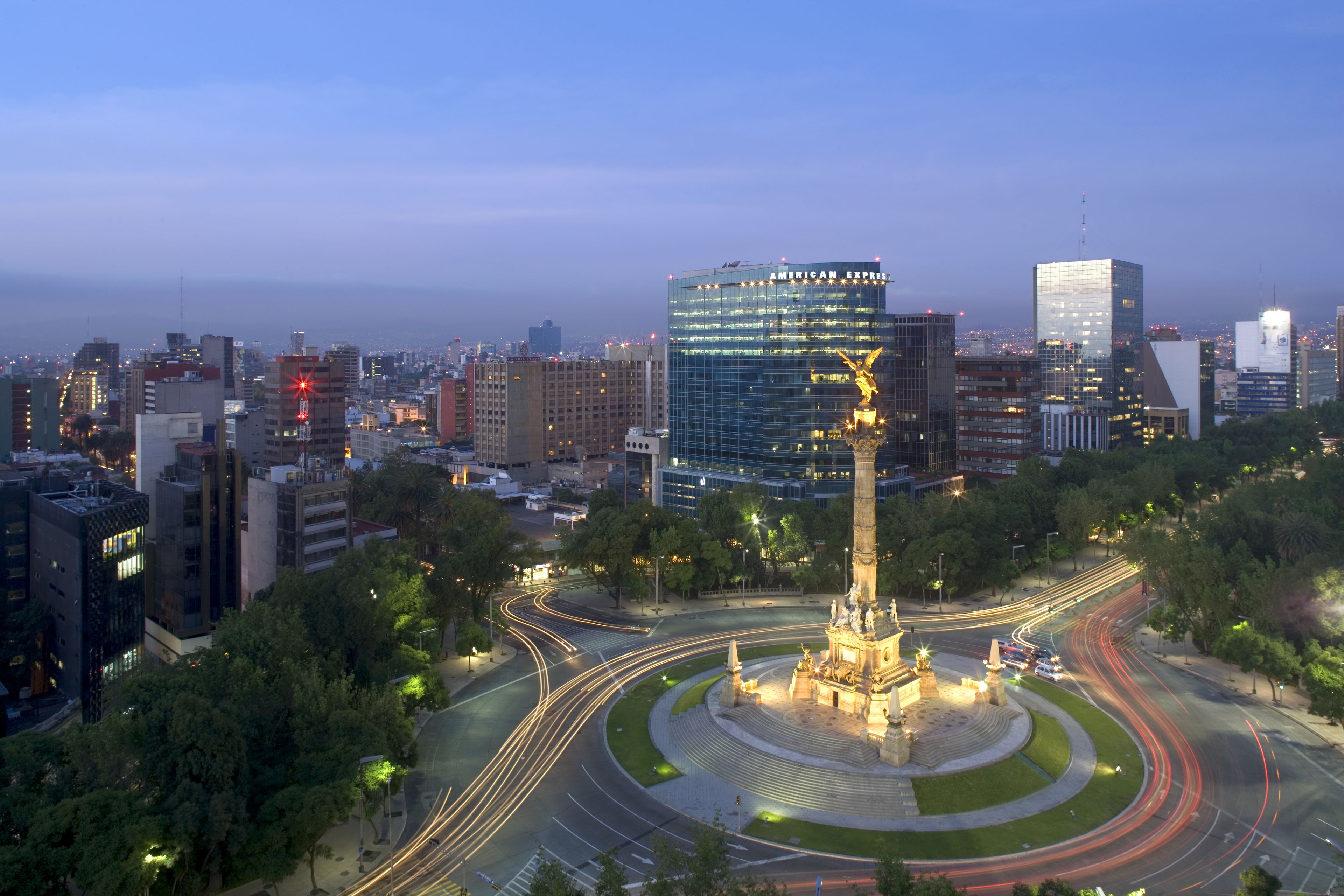 A cityscape with a prominent monument in the center, surrounded by roads and modern buildings.