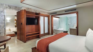 A hotel room with a bed, a TV, a seating area, and a bathroom with a bathtub and shower.