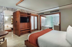 A hotel room with a bed, a TV, a seating area, and a bathroom with a bathtub and shower. - Costa d'Este Beach Resort and Spa (Vero Beach)