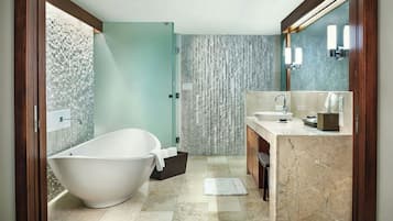 A modern bathroom with a freestanding bathtub, a vanity with a sink and mirror, and a textured wall.
