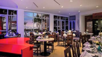 Un restaurante con varias mesas, sillas y un piano.