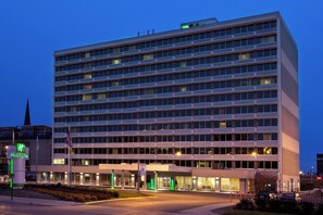 Ein mehrstöckiges Hotel mit schlichter Fassade, großen Fenstern und einem Holiday Inn Schild.
