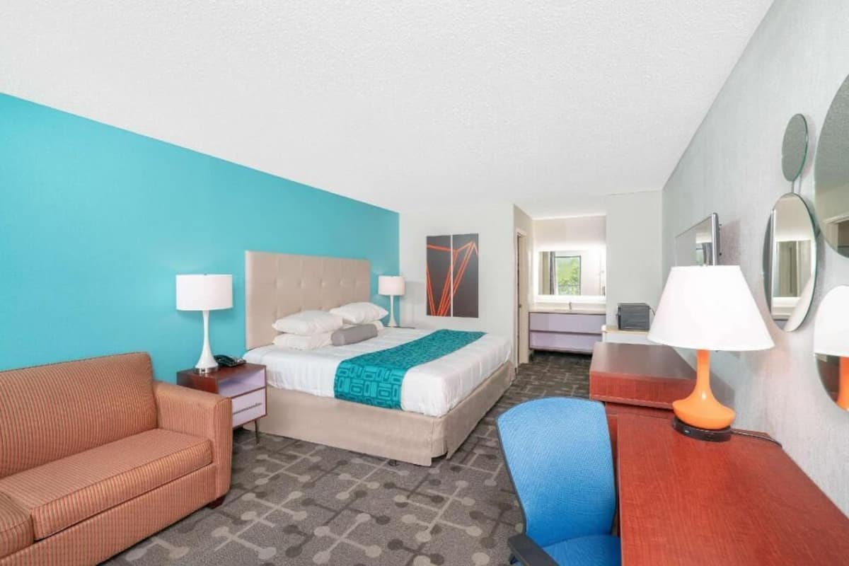 Une chambre d’hôtel avec un lit, un canapé, un bureau et une chaise.