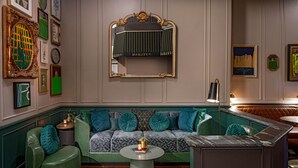 A cozy seating area with a green sofa, a round coffee table, and a bar area with a marble countertop.