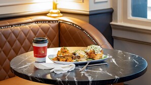 A dining table with a coffee cup and a plate of food.