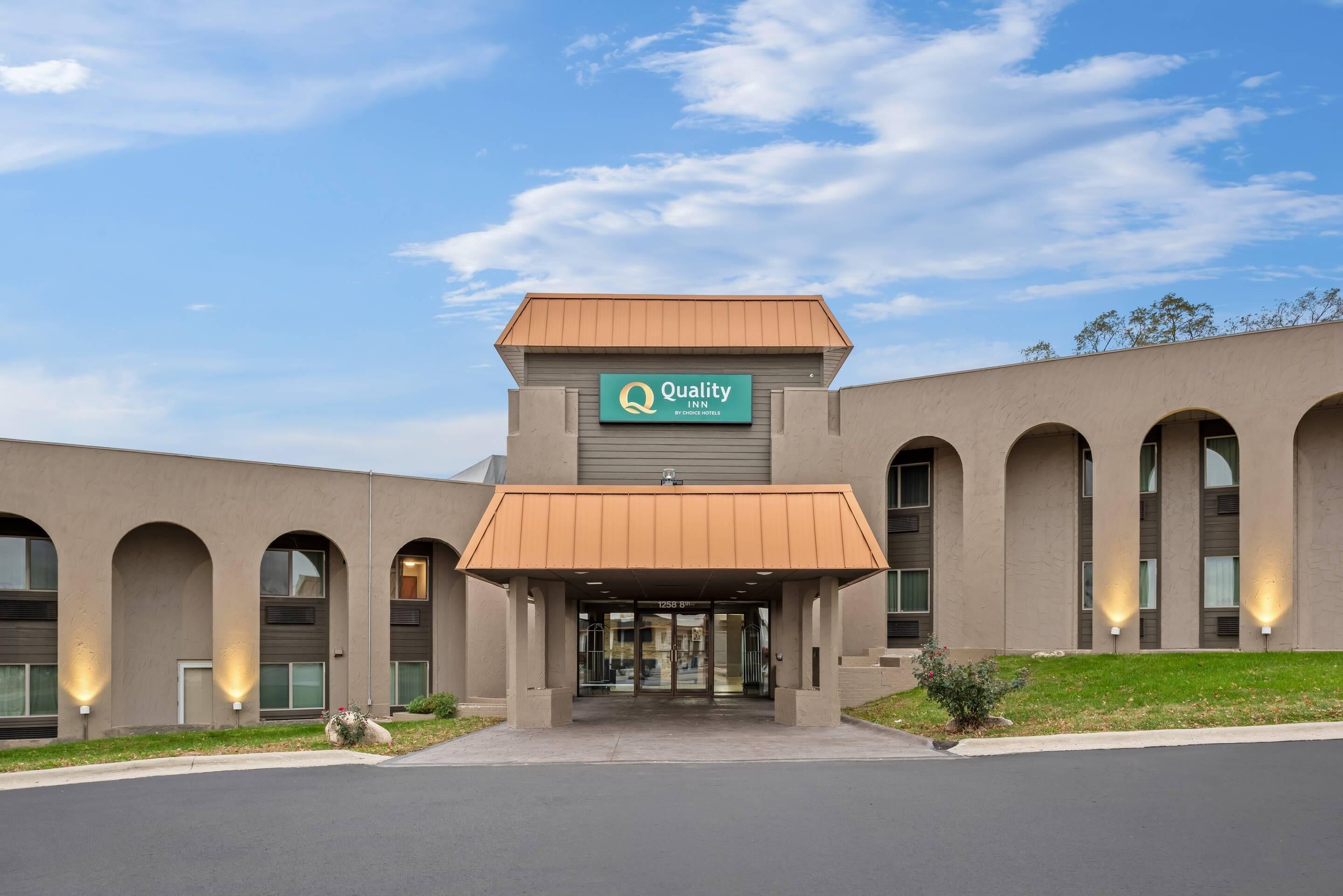 A Quality Inn with a modern facade, arched windows, and a covered entrance.