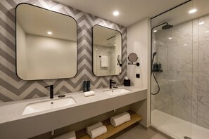 Habitación Deluxe, 1 cama King size | Baño | Regadera, amenidades de baño ecológicas, secadora de cabello, batas 