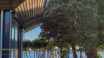 A modern building with a sloped roof, a wooden deck, and a view of the water.