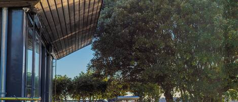 A modern building with a sloped roof, a wooden deck, and a view of the water.