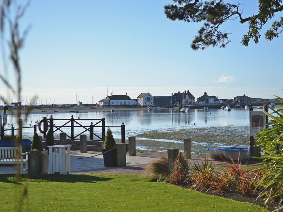 A waterfront view with a dock, boats, and buildings in the background.