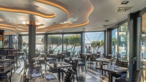 Un restaurante con una decoración moderna, ventanas amplias y vistas al agua.