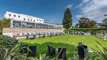 Un hotel con terraza y jardín.