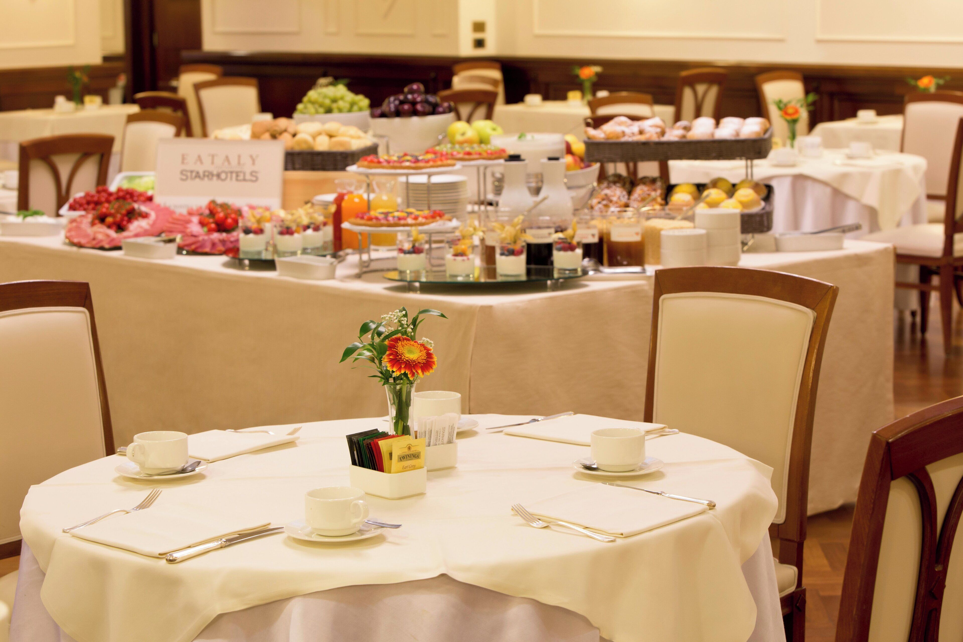 Montaje de bufé con diversas opciones de comida y un cartel que dice 'EATALY STARHOTELS'.