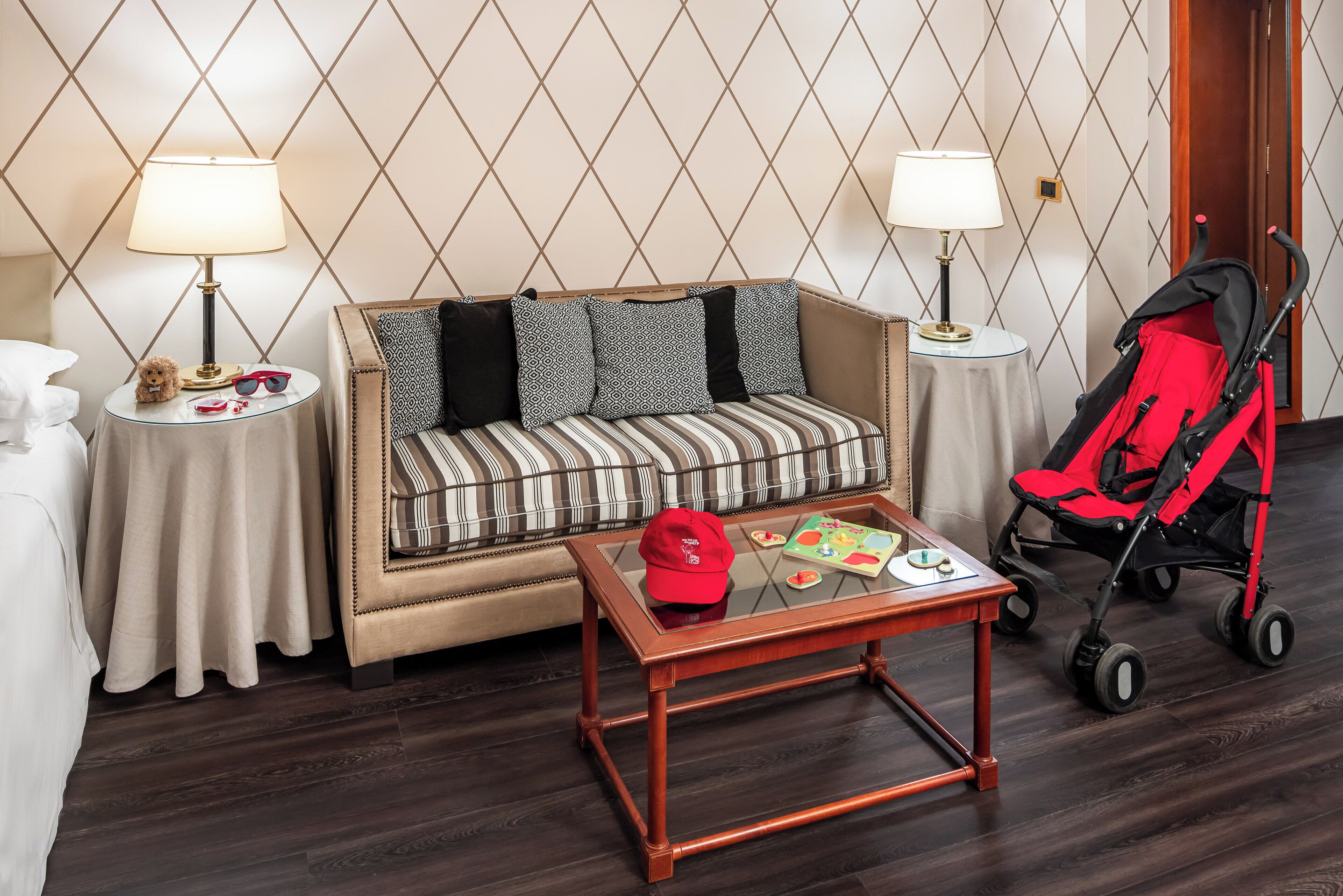 Un salon chaleureux avec un canapé, une table basse et une poussette rouge.