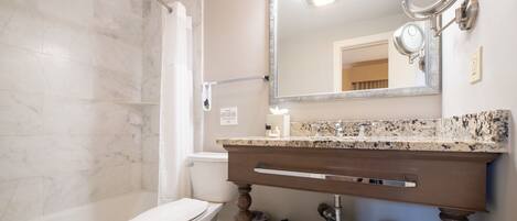 Une salle de bain avec des toilettes, une douche et un lavabo.