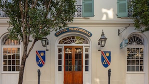 A building with a sign reading "Hotel Provincial" and two shield-shaped emblems on the facade. - Hotel Provincial (New Orleans)
