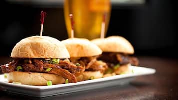 Three pulled pork sandwiches on a white plate.