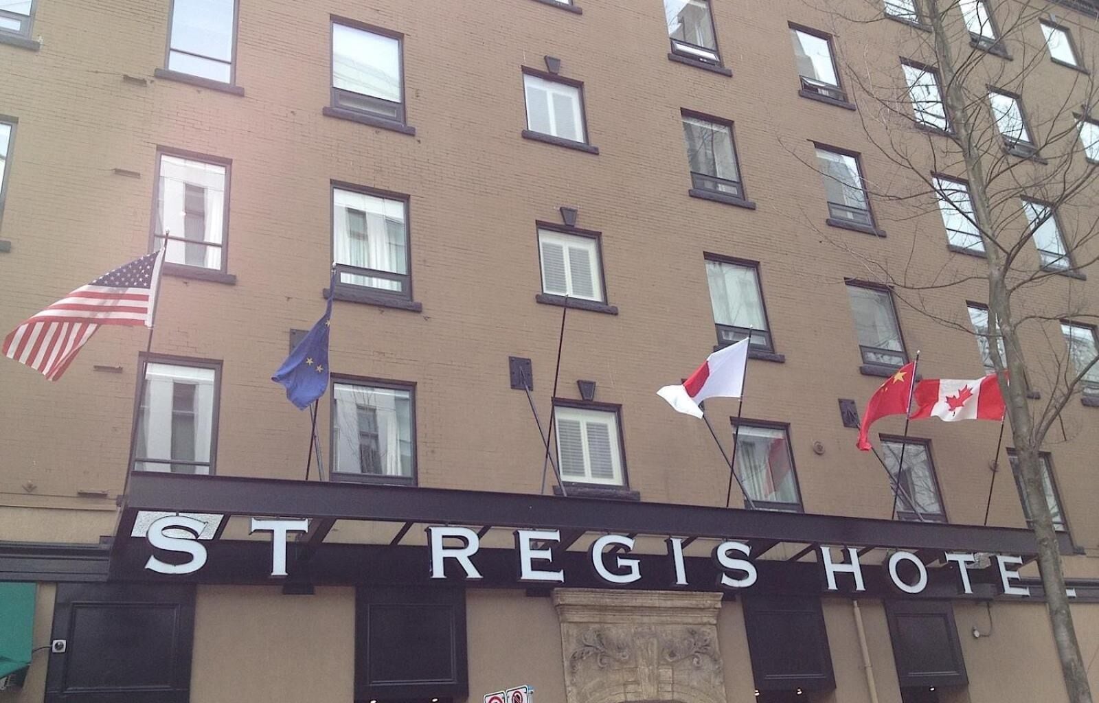 Un edificio de varios pisos con el letrero "St Regis Hotel" a nivel de calle.