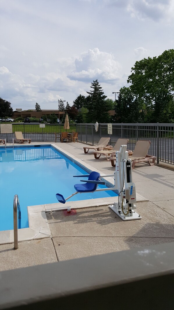 A swimming pool with lounge chairs and a lifeguard stand. - The Hotel@Dayton South (Dayton)