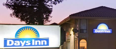 A Days Inn sign and building facade with a clear sky in the background.