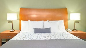 A hotel room with a bed, two bedside tables, two lamps, and a telephone on one of the tables. - Days Inn by Wyndham San Jose (San Jose)