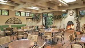 A restaurant with outdoor seating, a fireplace, and a statue.