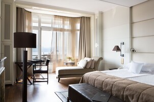 Una habitación de hotel con cama, escritorio, silla y vista al exterior.