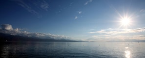 A calm lake with a clear sky and distant mountains.