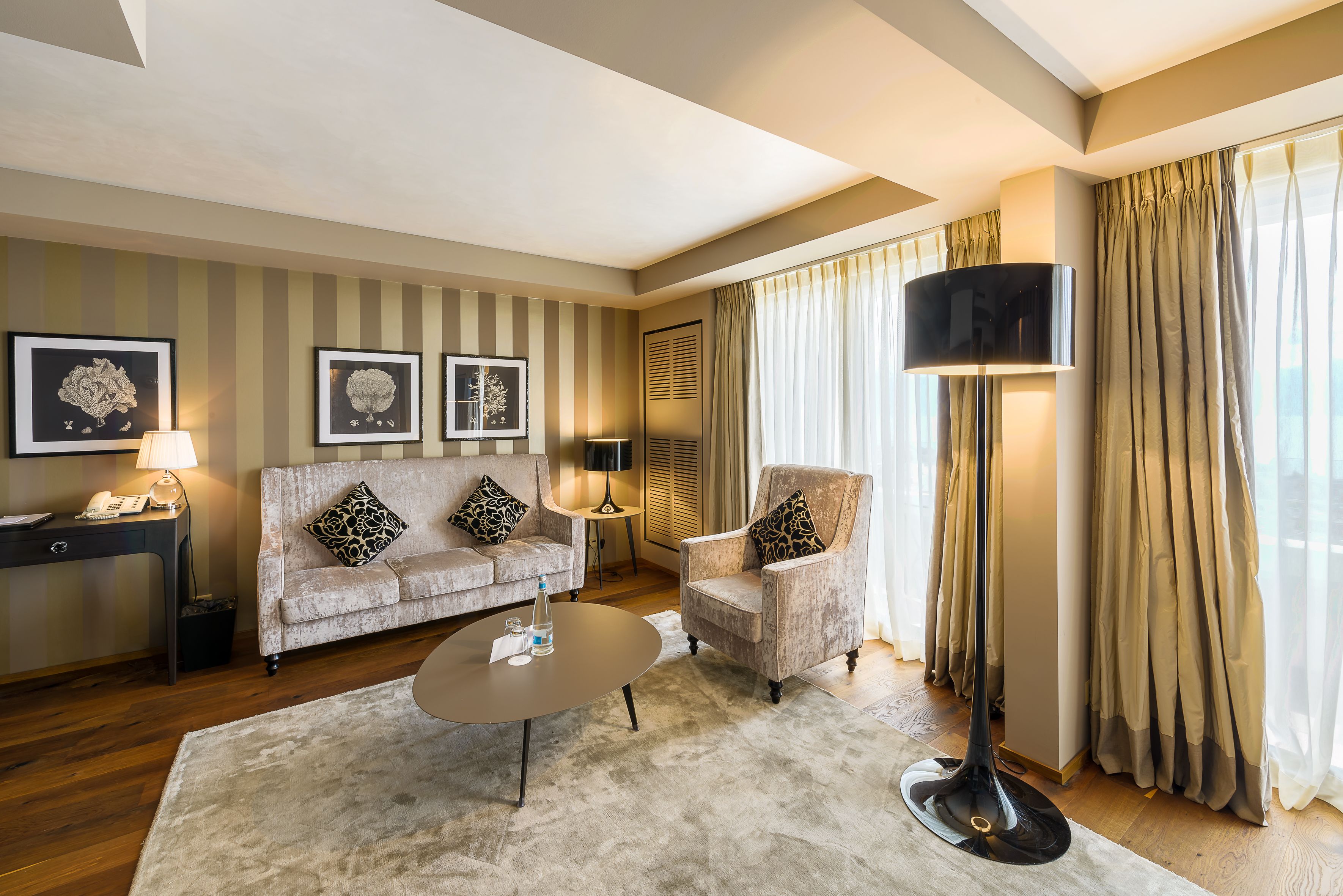 Una sala de estar con sofá, sillón, mesa de centro y televisor de pantalla plana.