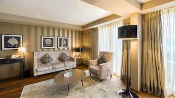 Una sala de estar con sofá, sillón, mesa de centro y televisor de pantalla plana.